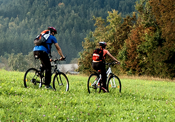 man-and-woman-biking-through-trail