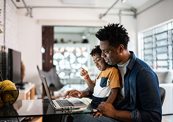 Father and young son working on a laptop